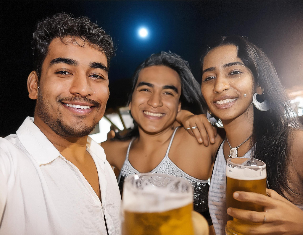 Three people, their faces hidden in shadows clinking glasses filled with beer under the light of a moon.