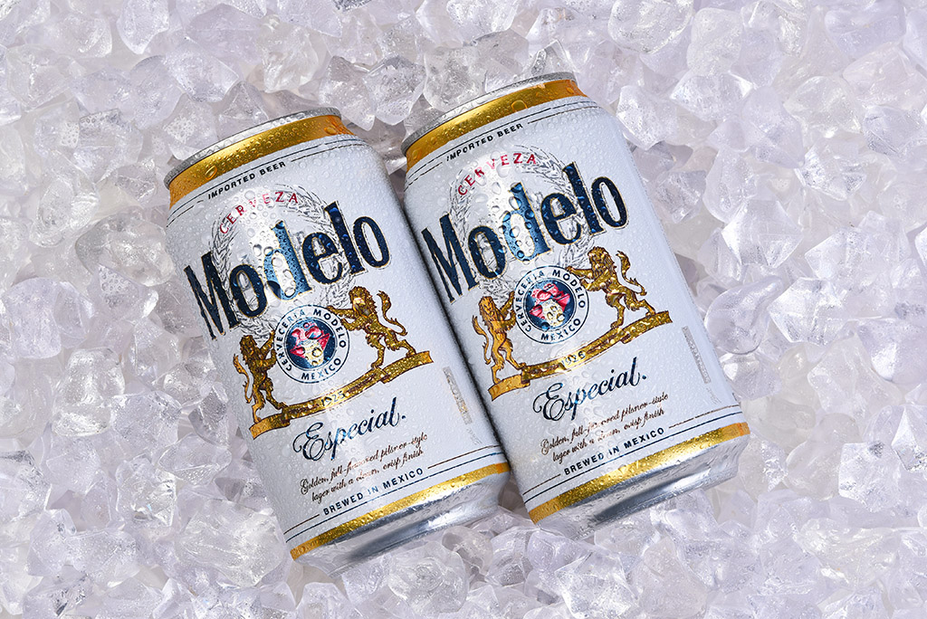 Two cans of Modelo Especial Mexican beer resting on ice